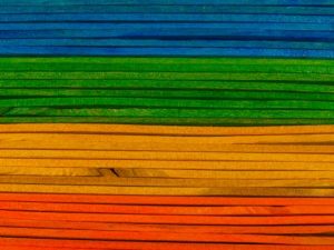 Colorful stack of wooden boards creating vibrant rainbow pattern. Ideal for diversity and equality themes.